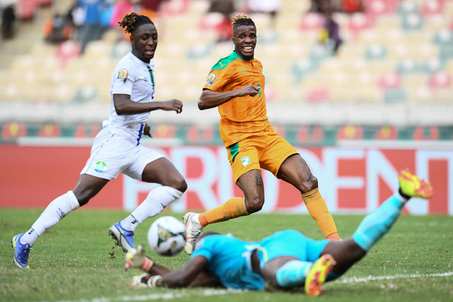 Pemain Pantai Gading Wilfred Zaha bereaksi saat kiper Sierra Leone Mohamed Nbalie Kamara melakukan penyelamatan di Stade de Japoma di Douala, Kamerun, Minggu (16/1). Foto: CHARLY TRIBALLEAU/AFP
