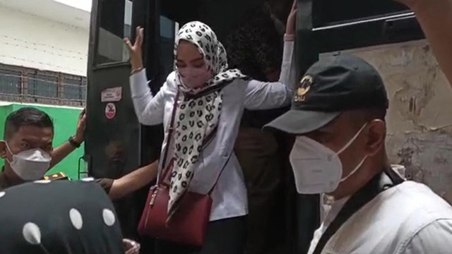 ANAK perempuan tersangka kasus pelecehan seksual yang juga Dekan FISIP Unri, Syafri Harto, diminta turun oleh jaksa saat ayahnya dibawa ke atas mobil tahanan Kejari Pekanbaru, Senin (17/1/2022). (FOTO: SELASAR RIAU/DEFRI CANDRA)