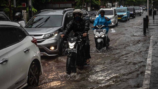 Kendaran melintasi genangan banjir di Jalan Cikini Raya, Jakarta, Selasa (18/1/2022). Foto: Aprillio Akbar/ANTARA FOTO