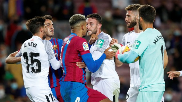 Pemain FC Barcelona Ronald Araujo bentrok dengan pemain Granada Domingos Duarte di Camp Nou, Barcelona, Spanyol. Foto: Albert Gea/Reuters