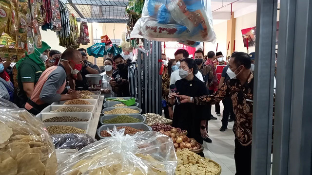 Ketua DPR RI sekaligus Ketua DPP PDIP, Puan Maharani, menerima mikrofon yang diserahkan Ketua DPC PDIP Solo, FX Hadi Rudyatmo, di Pasar Legi, Solo, Kamis (20/01/2022). FOTO: Agung Santoso