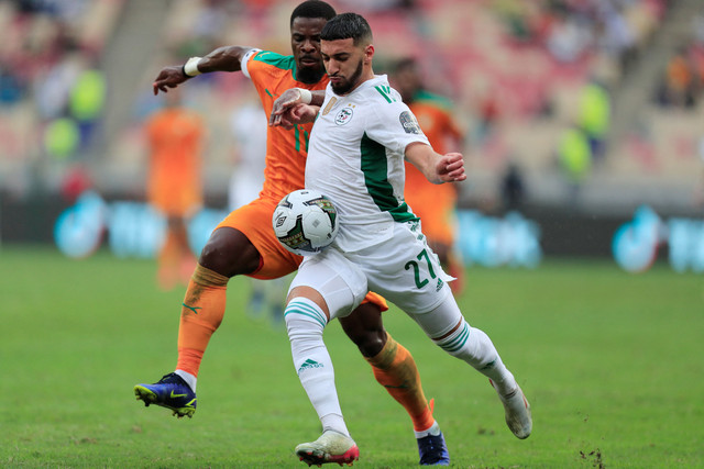 Pemain Pantai Gading Serge Aurier duel dengan pemain Aljazair Said Benrahma saat pertandingan Piala Afrika di Stade de Japoma, Douala, Kamerun, Kamis (20/1/2022). Foto: Thaier Al-Sudani/Reuters