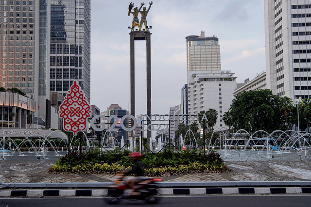 Pengendara motor melintas di depan logo Presidensi G20 Indonesia 2022 di Bundaran HI, Jakarta, Jumat (21/1/2022). Foto: Sigid Kurniawan/ANTARA FOTO