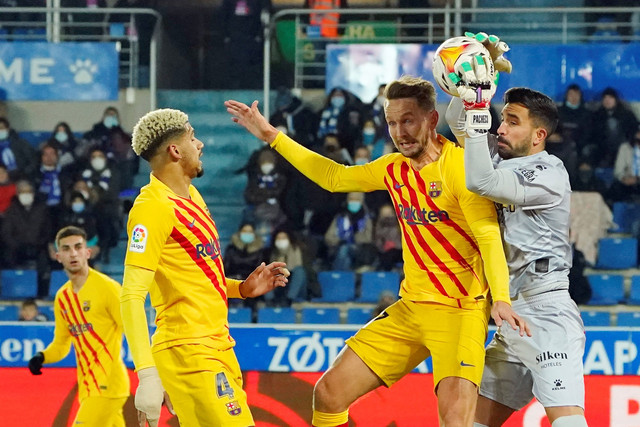 Pemain FC Barcelona Luuk de Jong berebut bola dengan penjaga gawang Deportivo Alaves pada pertandingan lanjutan Liga Spanyol di Estadio Mendizorroza, Vitoria-Gasteiz, Spanyo, Senin (24/1/2022). Foto: Vincent West/REUTERS