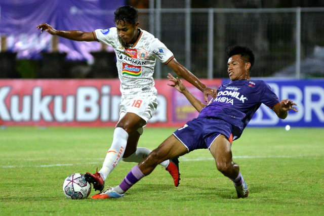 Pemain Persija Jakarta Alfriyanto Nico Saputro (kiri) berebut bola dengan pemain Persita Tangerang Muhamad Kasim Botan pada pertandingan Liga 1 di Stadion I Gusti Ngurah Rai, Denpasar, Bali, Rabu (26/1/2022).  Foto: Fikri Yusuf/ANTARA FOTO