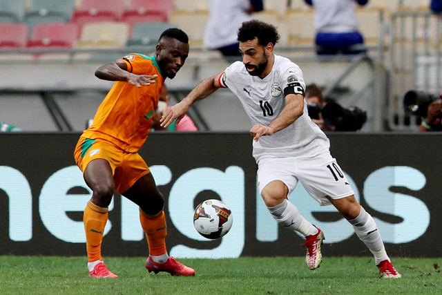Pemain Mesir Mohamed Salah berusaha melewati pemain Pantai Gading Ghislain Konan pada pertandingan 16 besar Piala Afrika 2021 di Stadion Douala, Douala, Kamerun, Rabu (26/1/2022).  Foto: Mohamed Abd El Ghany/REUTERS