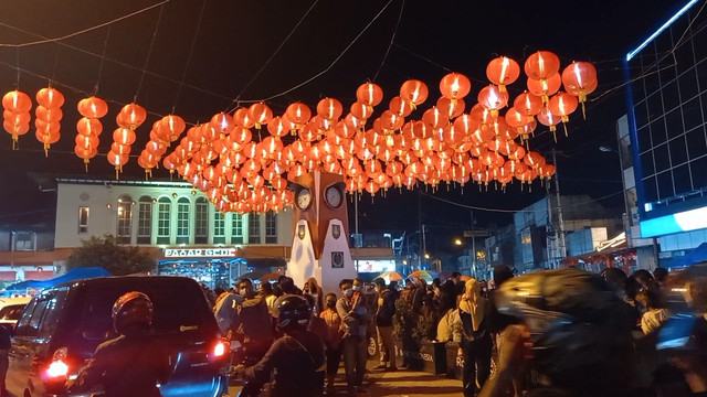 Lampion Imlek 2022 yang dipasang di tugu jam Pasar Gede, Solo dipadati warga, Minggu (30/01/2022) malam. FOTO: Agung Santoso