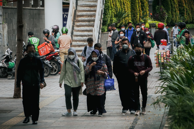 Pekerja berjalan sepulang kerja di kawasan Jalan Jenderal Sudirman, Jakarta, Rabu (2/2/2022). Foto: Jamal Ramadhan/kumparan
