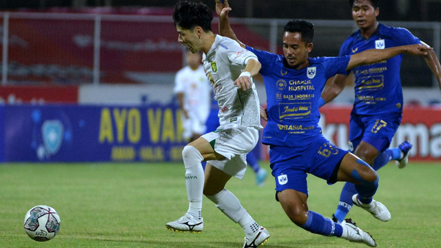 Pemain Persebaya Surabaya Taisei Marukawa duel dengan pemain PSIS Semarang Taufik Hidayat saat pertandingan Liga 1 di Stadion I Gusti Ngurah Rai, Denpasar, Bali, Rabu (2/2/2022). Foto: Fikri Yusuf/Antara Foto