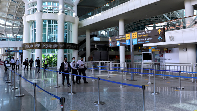 Pekerja melintas di area Terminal Internasional yang lengang di Bandara Internasional I Gusti Ngurah Rai, Badung, Bali, Rabu (2/2/2022). Foto: Fikri Yusuf/Antara Foto