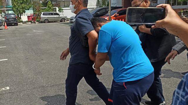 AR digiring ke mobil pribadi yang akan membawanya ke Rutan Mapolresta Pekanbaru, Jumat (4/2/2022). Awalnya kasus ini dilaporkan oleh orang tua korban dengan dugaan pemerkosaan, kemudian berubah jadi pencabulan dan persetubuhan dan saat ditahan dengan pasal pencurian. 