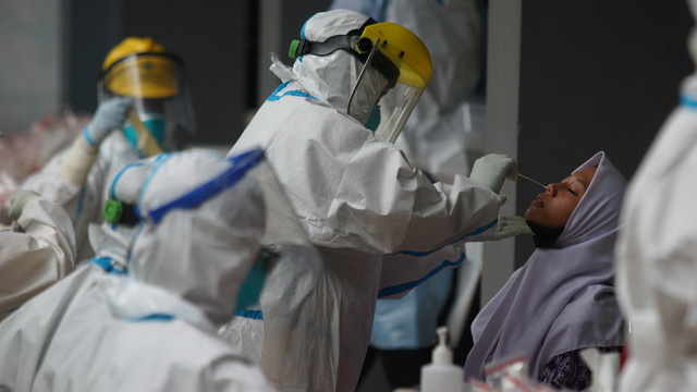 Petugas kesehatan mengambil sampel tes Swab PCR COVID -19 untuk guru dan siswa saat pelacakan kluster sekolah di SMA N 1 Bantul, D.I Yogyakarta, Sabtu (5/2/2022). Foto: Andreas Fitri Atmoko/Antara Foto