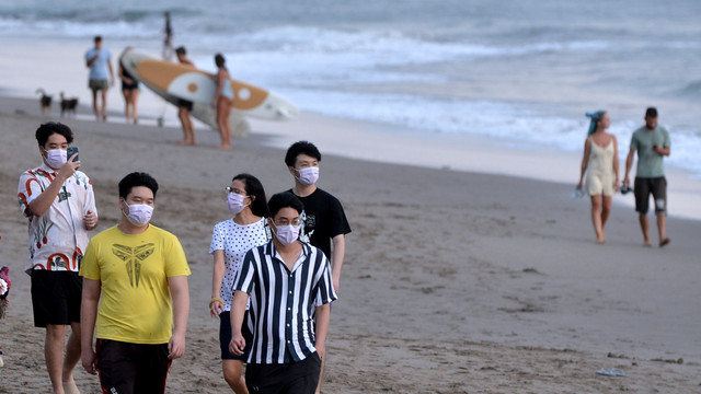 Warga membersihkan papan selancar untuk disewakan kepada wisatawan di kawasan wisata Pantai Batu Bolong, Canggu, Badung, Bali, Senin (7/2/2022). Foto: Fikri Yusuf/Antara Foto