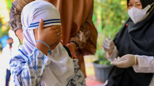 Seorang anak menutup saat hendak divaksin Corona di MIN I Banda Aceh. Foto: Suparta/acehkini 