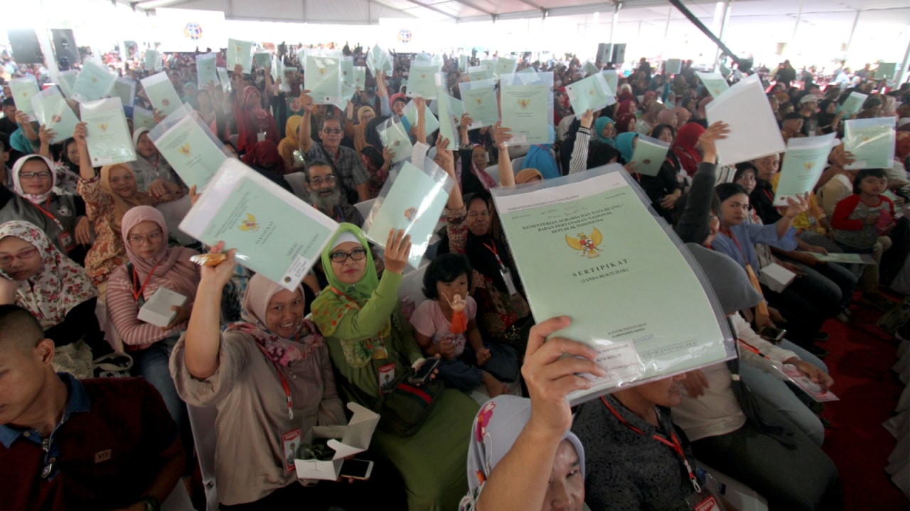 Warga menunjukan sertifikat dalam pembagian Sertifikat Tanah untuk Rakyat di Bogor