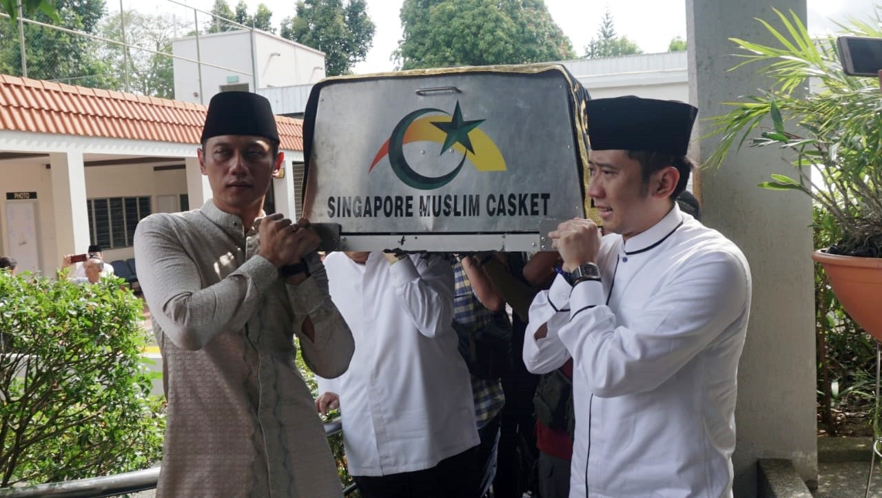 Ani Yudhoyono, Agus Harimurti  (kiri) dan Edhie Baskoro (kanan) mengangkat keranda jenazah Ani Yudhoyono yang telah tiba di Masjid Istiqamah, KBRI Singapura