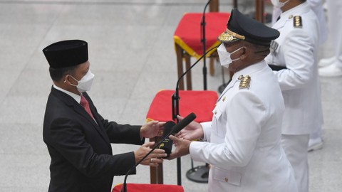 Menteri Dalam Negeri Tito Karnavian (kiri) menyerahkan surat keputusan kepada Pj. Gubernur Papua Barat Paulus Waterpauw (kanan) saat pelantikan lima penjabat gubernur di Kemendagri, Jakarta, Kamis (12/5/2022). Foto: Hafidz Mubarak A/ANTARA FOTO