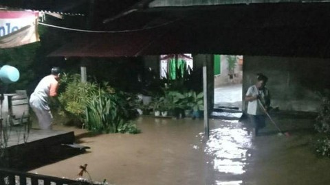 Sejumlah warga Desa Korobono Kecamatan Pamona Tenggara Kabupaten Poso Provinsi Sulawesi Tengah (Sulteng) berada di sekitar rumah miliknya yang tergenang banjir, Kamis (12/5/2022) malam. Foto: BPBD Sulteng/Antara