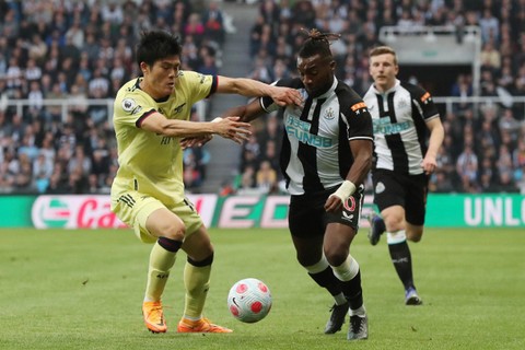 Pemain Arsenal Takehiro Tomiyasu berebut bola dengan pemain Newcastle United Allan Saint-Maximin pada pertandingan lanjutan Liga Inggris di Stadion St James' Park, Newcastle, Inggris. Foto: Scott Heppell/REUTERS