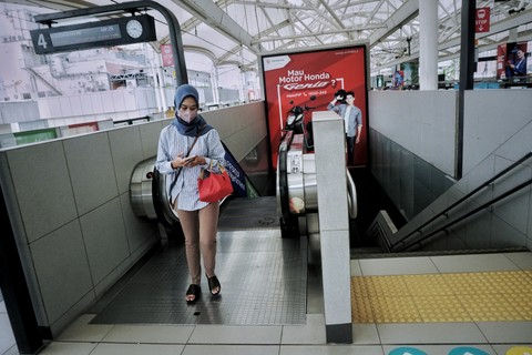 Seorang perempuan berjalan menunju transportasi publik MRT di Jakarta, Jumat (20/5/2022). Foto: Jamal Ramadhan/kumparan