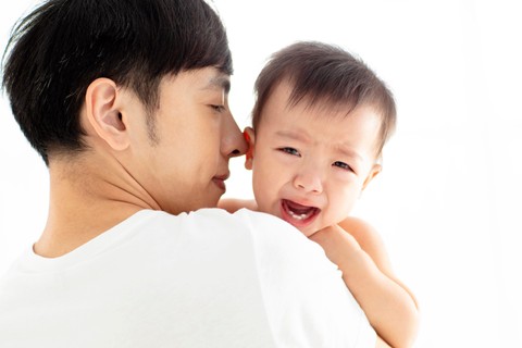 Ilustrasi bayi menangis digendong ayah. Foto: Tom Wang/Shutterstock