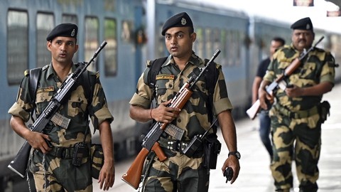 Tentara Pasukan Keamanan Perbatasan India (BSF) berpatroli di sebelah kereta 'Bandhan Express' di stasiun kereta api di Kolkata, India pada Minggu (29/5/2022). Foto: Dibyangshu Sarkar/AFP