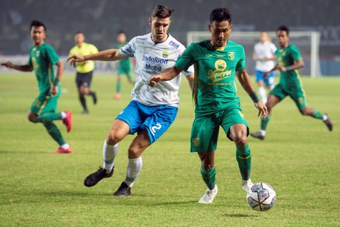 Pemain Persib Bandung Nick Kuipers (kiri) berebut bola dengan pemain Persebaya Surabaya Januar Eka (kanan) saat pertandingan Group C Piala Presiden 2022 di Stadion Gelora Bandung Lautan Api, Bandung, Jawa Barat, Jumat (17/6/2022).  Foto: M Agung Rajasa/ANTARA FOTO