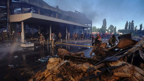 Tim penyelamat sibuk bekerja di lokasi pusat perbelanjaan yang terkena serangan rudal Rusia di Kremenchuk, wilayah Poltava, Ukraina, Senin (27/6/2022). Foto: Anna Voitenko/Reuters