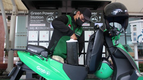 Seorang pengemudi ojek daring mengganti baterai motor listriknya di SPKLU Gedung PLN Gambir, Jakarta, Rabu (13/0/2022). Foto: Agha Yuninda/ANTARA FOTO