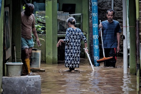 Warga membersihkan lumpur usai air banjir di Kebon Pala, Kampung Melayu, Kecamatan Jatinegara, Jakarta Timur, Sabtu (16/7/2022).  Foto: Jamal Ramadhan/kumparan