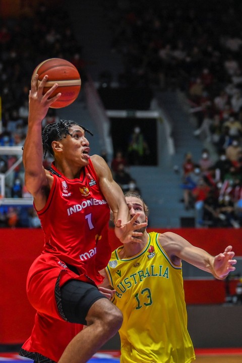 Pebasket Indonesia Derrick Michael Xzavierro (kiri) melakukan lay up melewati pebasket Australia Samson James Froling (kanan) dalam babak penyisihan Grup A FIBA Asia Cup 2022 di Istora Gelora Bung Karno, Senayan, Jakarta, Sabtu (16/7/2022).  Foto: Galih Pradipta/ANTARA FOTO