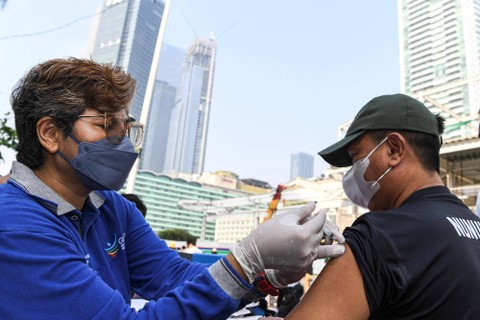 Petugas kesehatan menyuntikkan vaksin COVID-19 saat Car Free Day atau Hari Bebas Kendaraan Bermotor di kawasan MH Thamrin, Jakarta, Minggu (31/7/2022). Foto: M Risyal Hidayat/Antara Foto  