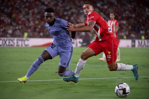 Pemain Real Madrid Vinicius Junior beraksi dengan pemain Spanyol Almeria Aitor Bunuel di Estadio de los Juegos Mediterraneos, Almeria, Spanyol, Minggu (14/8/2022). Foto: Jorge Guerrero/AFP