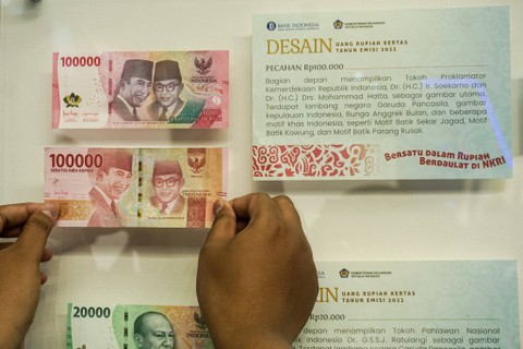 Pengunjung membandingkan desain uang di acara Festival Rupiah Berdaulat Bank Indonesia (FERBI) 2022 di GOR Basket Indoor GBK Senayan, Jakarta pada Jumat (19/8). Foto: Iqbal Firdaus/kumparan
