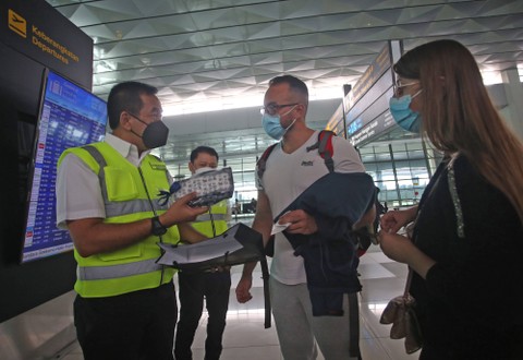 Direktur Utama PT Angkasa Pura II Muhammad Awaluddin (kiri) memberikan hadiah kepada calon penumpang wisatawan asing yang akan ke Bali di Terminal 3 Bandara Soekarno Hatta, Tangerang, Banten, Senin (5/9/2022). Foto: Muhammad Iqbal/ANTARA FOTO