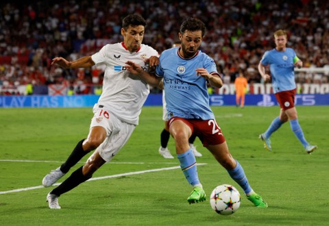 Pemain Manchester City Bernardo Silva duel dengan pemain Sevilla Jesus Navas saat pertandingan melawan Sevilla di Ramon Sanchez Pizjuan, Seville, Spanyol, Selasa (6/9/2022). Foto: Marcelo Del Pozo/Reuters