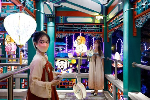 Wanita dengan pakaian tradisional Hanfu Cina memegang lentera berpose untuk foto sebelum festival Pertengahan Musim Gugur di kuil Wong Tai Sin di Hong Kong, Cina 8 September 2022.di kuil Wong Tai Sin, Hong Kong, Cina, Kamis (8/9/2022). Foto: Tyrone Siu/Reuters