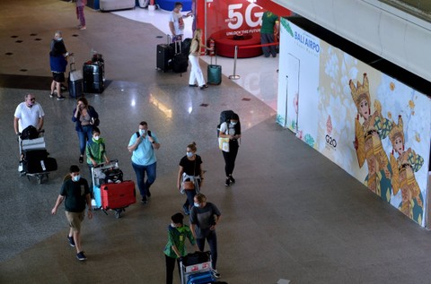 Sejumlah penumpang pesawat membawa barang bawaannya di area Terminal Internasional Bandara I Gusti Ngurah Rai, Badung, Bali, Kamis (29/9/2022). Foto: Fikri Yusuf/ANTARA FOTO