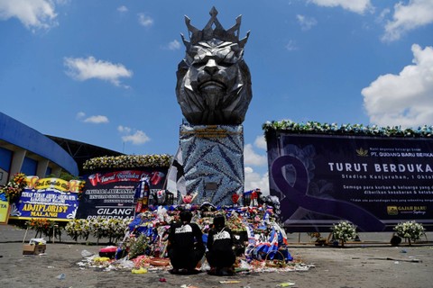 Warga berdoa di sekitar Patung Singa Stadion Kanjuruhan, Malang, Jawa Timur, usai insiden kerusuhan, Selasa (4/10/2022). Foto: Zabur Karuru/ANTARA FOTO