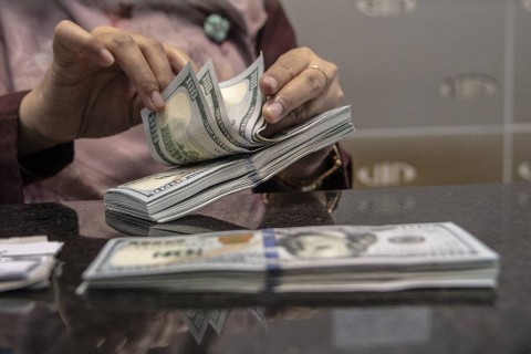 Petugas menghitung uang pecahan dolar AS di gerai penukaran mata uang asing VIP (Valuta Inti Prima) Money Changer, Jakarta, Selasa (4/10/2022). Foto: Muhammad Adimaja/Antara Foto