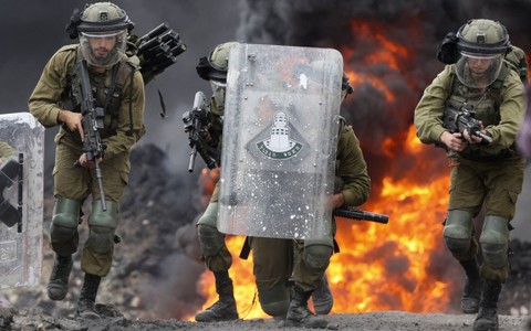 Tentara Israel dikerahkan di tengah bentrokan dengan demonstran Palestina saat protes terhadap pengambilalihan tanah Palestina oleh Israel di desa Kfar Qaddum di Tepi Barat, pada Jumat (7/10/2022). Foto: Jaafar Ashtiyeh/AFP