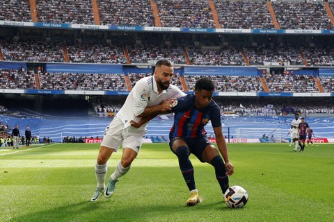 Pemain Real Madrid Dani Carvajal berebut bola dengan pemain FC Barcelona Alex Balde pada pertandingan lanjutan Liga Spanyol di Santiago Bernabeu, Madrid, Spanyol. Foto: Juan Medina/REUTERS