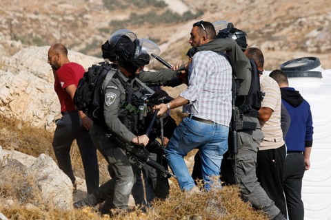 Warga Palestina terlibat bentrok dengan pasukan Israel di Hebron, Tepi Barat yang diduduki Israel, Selasa (25/10/2022). Foto: Mussa Qawasma/Reuters