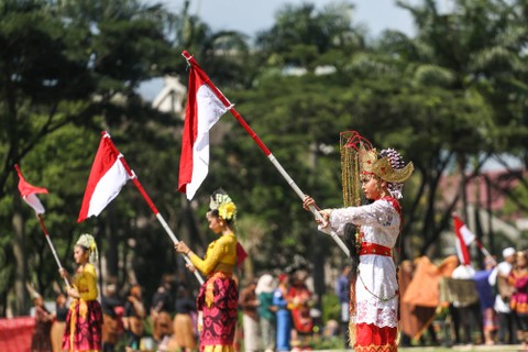 Sejumlah peserta mengibarkan bendera merah putih saat karnaval budaya di Taman Mini Indonesia Indah, Jakarta, Jumat (28/10/2022). Foto: Asprilla Dwi Adha/Antara Foto