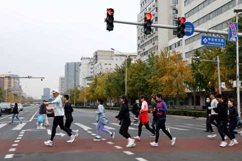 Anggota Oscar Running Club (ORC) berlari di pinggir jalan saat sesi latihan untuk Beijing Marathon 2022, di Beijing, China. Foto: Tingshu Wang/REUTERS