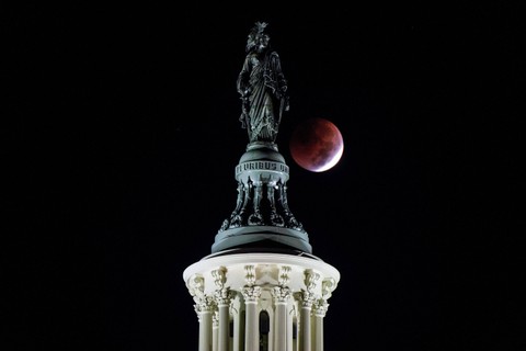 Gerhana bulan terlihat di belakang Patung Kebebasan di U.S di Washington, AS. Foto: Joshua Roberts/REUTERS