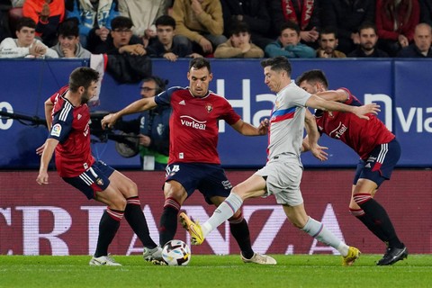 Pemain FC Bacelona Robert Lewandowski berusaha melewati pemain Osasuna pada pertandingan lanjutan Liga Spanyol di stadion El Sadar, Pamplona, Spanyol.  Foto: Cesar Manso/AFP