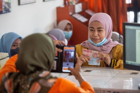 Warga penerima pantuan difoto oleh petugas saat mengambil Bantuan Subsidi Upah (BSU) di Kantor Pos Sedayu, Bantul, DI Yogyakarta, Sabtu (5/11/2022). Foto: Hendra Nurdiyansyah/ANTARA FOTO