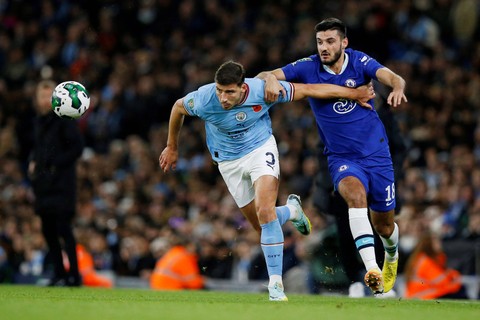 Pemain Manchester City Ruben Dias berebut bola dengan pemain  Chelsea Armando Broja  pada pertandingan babak ketiga Piala Carabao di Stadion Etihad, Manchester, Inggris. Foto: Craig Brough/REUTERS