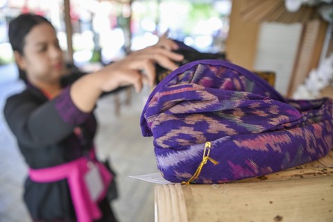 Perajin merapikan ikat kepala berbahan dasar kain tenun Endek yang dijual di pusat suvenir KTT G20 di Bali Collection, kawasan ITDC, Nusa Dua, Badung, Bali, Jumat (11/11/2022). Foto: M Risyal Hidayat/ANTARA FOTO